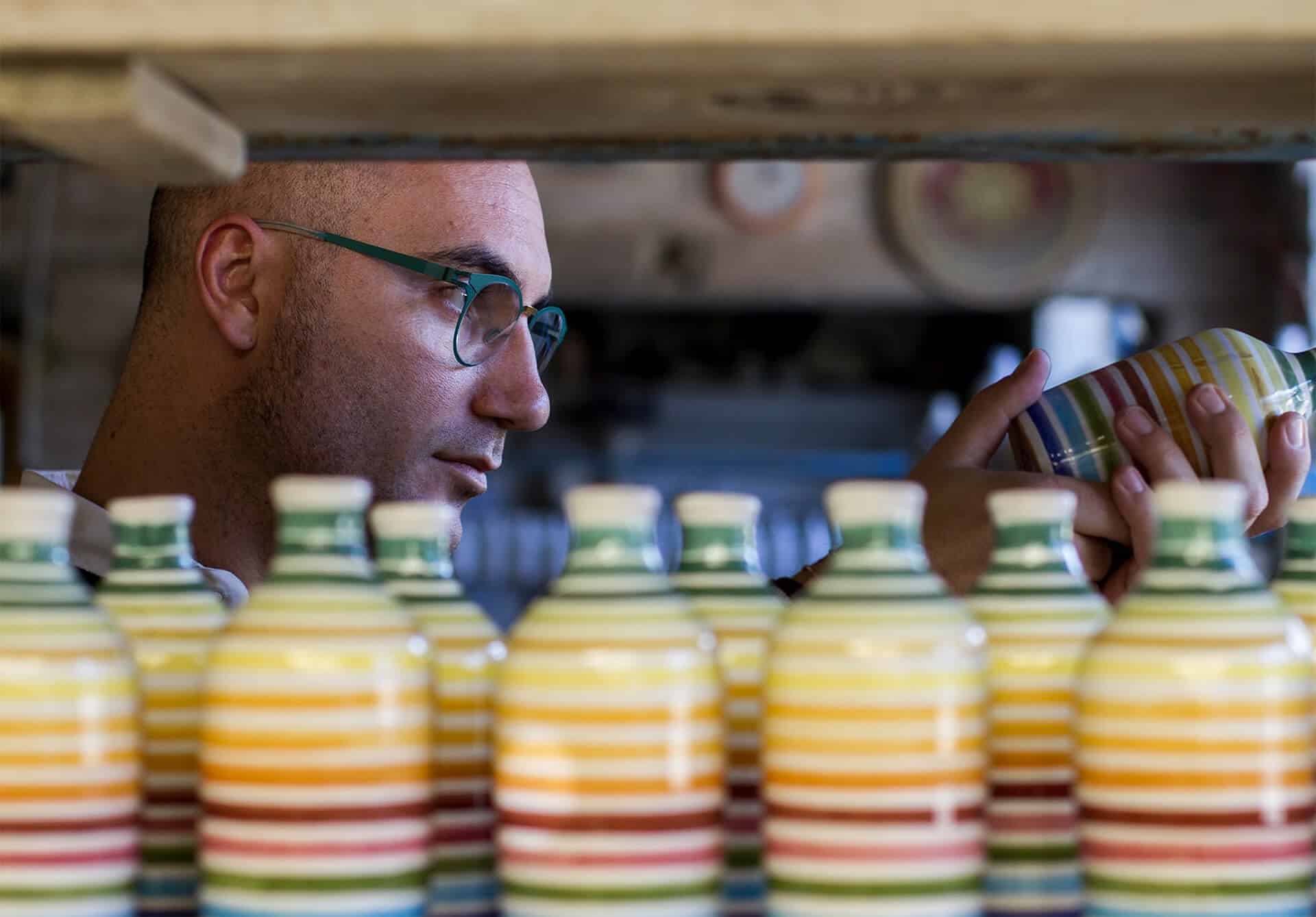 Uomo con occhiali osserva le bottiglie di olio extravergine Frantoio Muraglia sullo scaffale