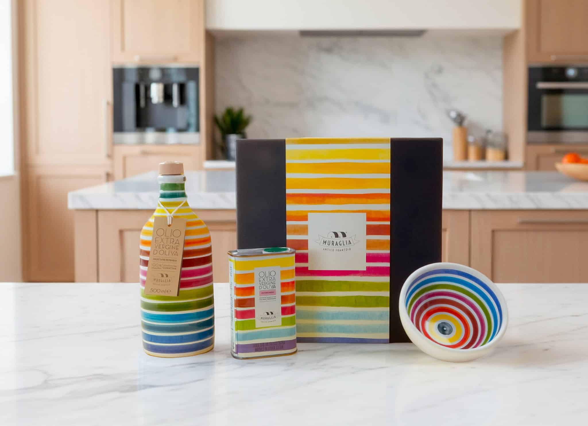 Bottiglia, lattina e ciotola a righe colorate con la confezione regalo in una cucina